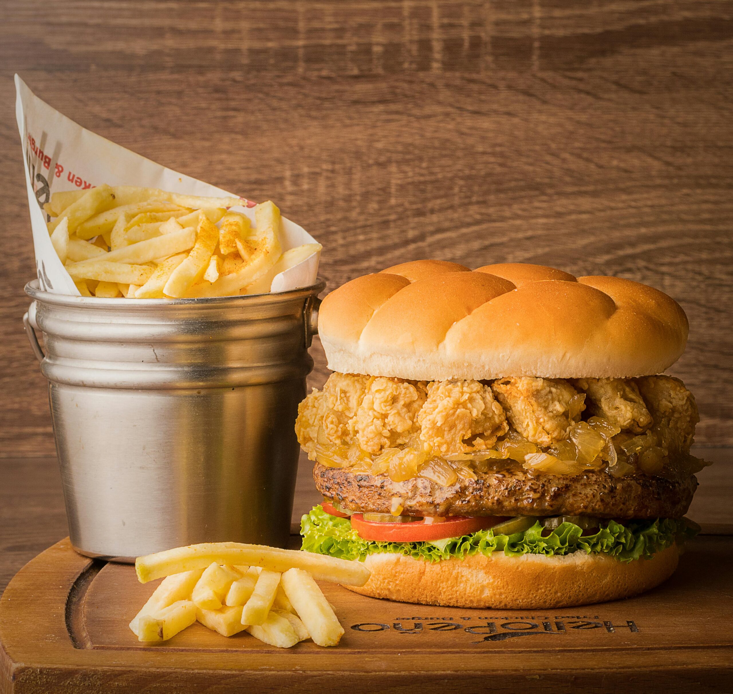 pexels photo 14710226 14710226 Delicious gourmet burger with crispy fried onions and fresh fries served on a wooden platter.