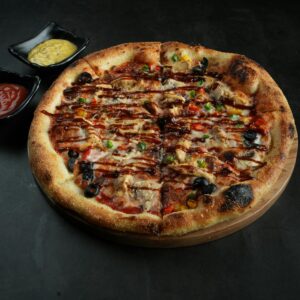 Shop1 Mouthwatering pizza with vibrant toppings served with two dipping sauces.