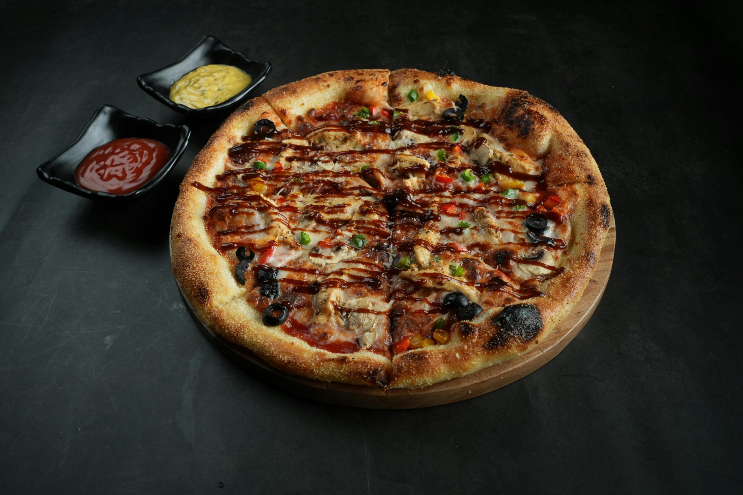 pexels photo 15832883 15832883 Mouthwatering pizza with vibrant toppings served with two dipping sauces.