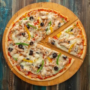 Shop1 Top view of a chicken pizza with olives and bell peppers on a wooden board.